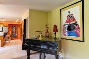 a piano in a living room with a picture on the wall at Arborhouse **** Naperville-Lisle in Lisle