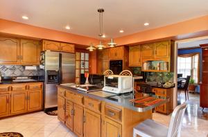 a large kitchen with wooden cabinets and a microwave at Arborhouse **** Naperville-Lisle in Lisle