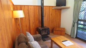 a living room with a couch and a wood stove at Broken River Mountain Resort in Eungella