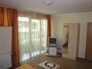 a living room with a television and sliding glass doors at Suri Guesthouse in Braşov