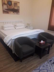 1 dormitorio con 1 cama, 1 silla y 1 mesa en Sea Inn, en Al Khobar