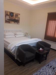 1 dormitorio con 1 cama grande y 1 silla en Sea Inn, en Al Khobar