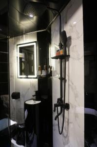 a bathroom with a shower with a sink and a mirror at Star City Hotel in Hong Kong