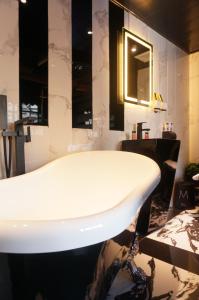 bagno con vasca bianca in una stanza di Star City Hotel a Hong Kong