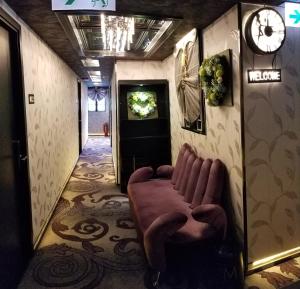 corridoio con sala d'attesa con divano e orologio di Star City Hotel a Hong Kong