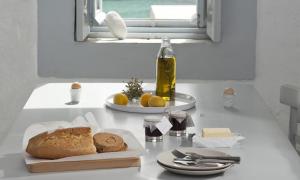 a white counter with a plate of bread and a window at Coco-Mat Eco Residences Serifos in Vayiá