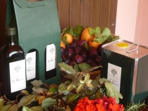 a bottle of wine sitting next to a basket of fruit at Agriturismo De Santis in Castiglioncello
