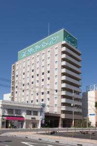 un gran edificio con un cartel encima en Hotel Route-Inn Nobeoka Ekimae en Nobeoka