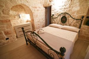 セルヴァ・ディ・ファザーノにあるIl Trullo Biancoの石造りのベッドルーム1室(ベッド1台付)