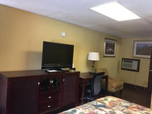 a hotel room with a bed and a television on a dresser at Americas Best Value Inn Stone Mountain Atlanta E in Stone Mountain