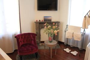 ein Wohnzimmer mit einem Stuhl und einem Tisch mit Blumen in der Unterkunft Les Bruyères in Les Sables-dʼOlonne