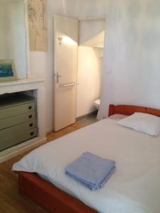 a bedroom with a white bed with a blue towel on it at La Laverie in Saint-Jean-dʼAngély