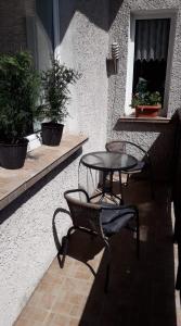 taras z dwoma krzesłami i stołem oraz oknem w obiekcie Wygodny Apartament w mieście Gdynia
