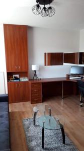 salon ze szklanym stołem i biurkiem w obiekcie Wygodny Apartament w mieście Gdynia