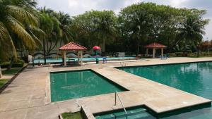 a swimming pool in a resort with palm trees at Homestay Bandar Putra Kulai in Kulai