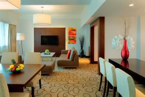 a living room with a table and a dining room at Radisson Hotel Brunei Darussalam in Bandar Seri Begawan