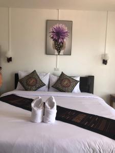 a bedroom with a bed with white shoes on it at Jasmine Vangvieng Hotel in Vang Vieng