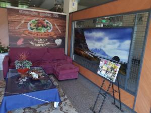 a room with a tv and a couch and a table at Shuanghu Garden B&B in Shuangxi