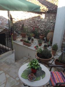 a patio with a table and potted plants on it at Proselinos in Dhimitsana