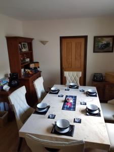 a dining room table with chairs and a table with a picture on it at Delny Muir House in Invergordon