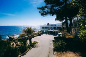 una strada vuota vicino all'oceano con un edificio di Hôtel Cala di Sole ad Ajaccio