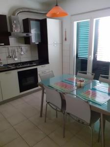 a kitchen with a glass table and chairs in a room at Apartment Računica in Vodice