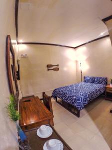 a bedroom with a bed and a wooden table at Coron Residencia de Rosario in Coron