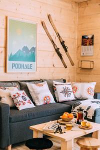 Czarna Owca في كوشتيليسكا: غرفة معيشة مع أريكة مع وسائد وطاولة