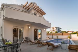 ブロダリツァにあるVilla Tamaraのパティオ(テーブル、椅子付)、スイミングプールが備わります。