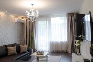 sala de estar con sofá y lámpara de araña en Luxury Dream Apartman, en Eger