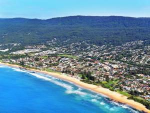 an aerial view of a beach with houses and the ocean at Thirroul Beach Motel in Wollongong