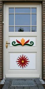 a white door with a flower painted on it at Ferienwohnungen Boddenfischer in Born