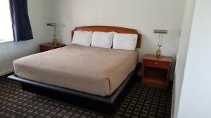 a hotel room with a bed and two night stands at Budget Inn Breezewood in Breezewood