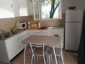 a kitchen with a table and chairs and a white refrigerator at d17 studio pietra in Mucchio