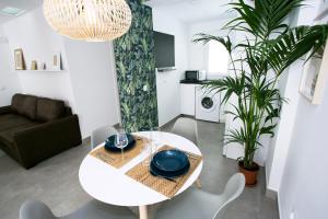 Biały stół i krzesła w salonie w obiekcie MONKÓ - MANGO & TROPYCAL APARTMENT o w mieście Torremolinos