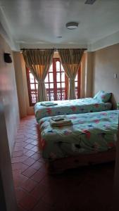 a bedroom with two beds and a window at Pottery Home in Bhaktapur