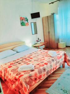 Un dormitorio con una cama con una manta roja. en Guest House Mila, en Plitvički Ljeskovac