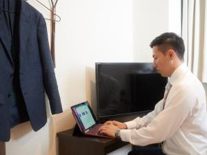 沖縄市にあるオキナワシティホテルのラップトップの前に座る男 +37枚の写真