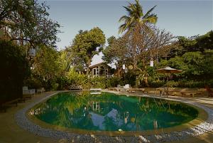 a swimming pool in the middle of a yard at Chakrabongse Villas in Bangkok