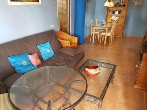 a living room with a couch and a glass table at Apartamentos Atlanterra COSTA Y SOL in Zahara de los Atunes