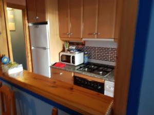 a kitchen with a microwave and a stove and refrigerator at Apartamentos Atlanterra COSTA Y SOL in Zahara de los Atunes