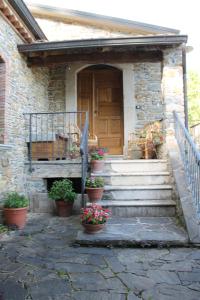 una casa con portico con piante in vaso e porta di Case Vacanza S. Nicola a Viggianello