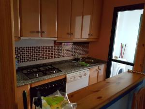 a kitchen with a sink and a stove top oven at Apartamentos Atlanterra COSTA Y SOL in Zahara de los Atunes