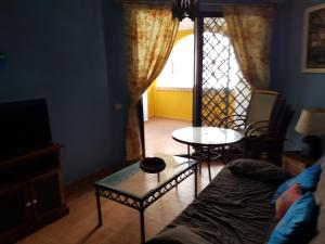 a living room with a couch and a glass table at Apartamentos Atlanterra COSTA Y SOL in Zahara de los Atunes