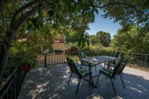 eine Terrasse mit einem Tisch und Stühlen unter einem Baum in der Unterkunft Holiday Home Suzana 1276 in Kaštel