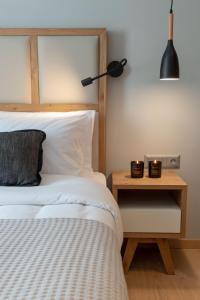 ein Schlafzimmer mit einem Bett und einem Beistelltisch mit einer Lampe in der Unterkunft Grand Port Suites in Thessaloniki