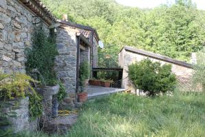 a stone house with a porch and a garden at Case Vacanza S. Nicola in Viggianello