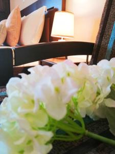 un vaso di fiori bianchi seduto su un tavolo di Pension Anastasia ad Ammouliani