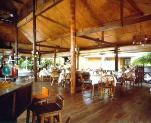 una zona de comedor con mesas y sillas y un restaurante en Utopia Resort, en Lamai