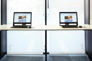two laptops sitting on a desk in front of a window at Tokyu Stay Kamata - Tokyo Haneda in Tokyo